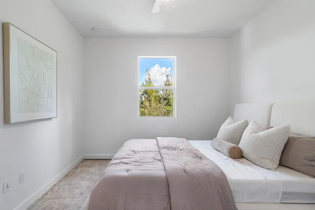 a bedroom with a bed and painting on the wall
