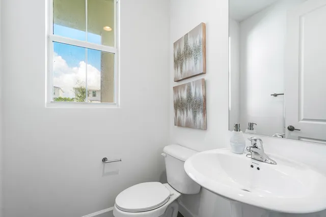 a bathroom with a sink mirror and toilet