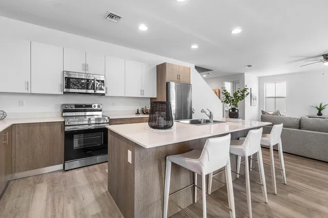 a kitchen with stainless steel appliances a stove a sink a microwave a refrigerator and cabinets