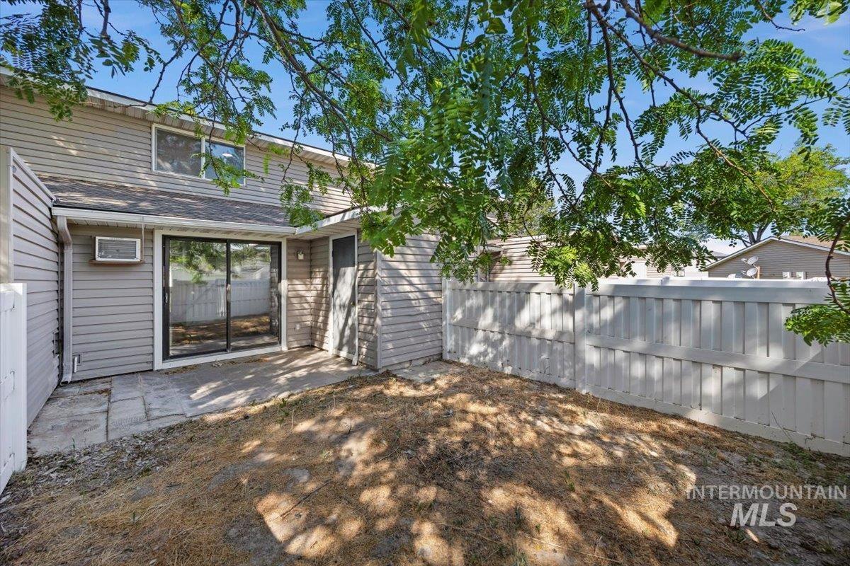 259 Pheasant Road, Unit 84 Twin Falls, ID 83301 - Photo 20 of 25 Private patio area featuring a sliding glass door, a window unit air conditioner, and a privacy fence