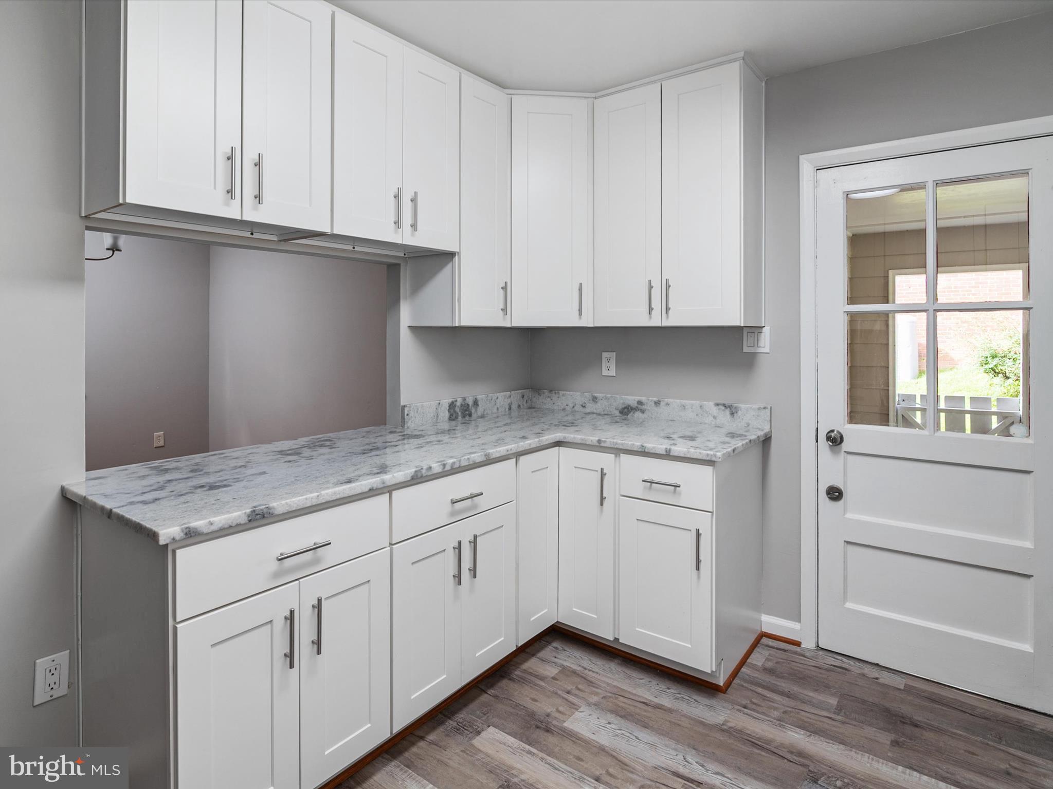 806 Downs Drive Silver Spring, MD 20904 - Photo 14 of 36 a kitchen with granite countertop cabinets and wooden floor