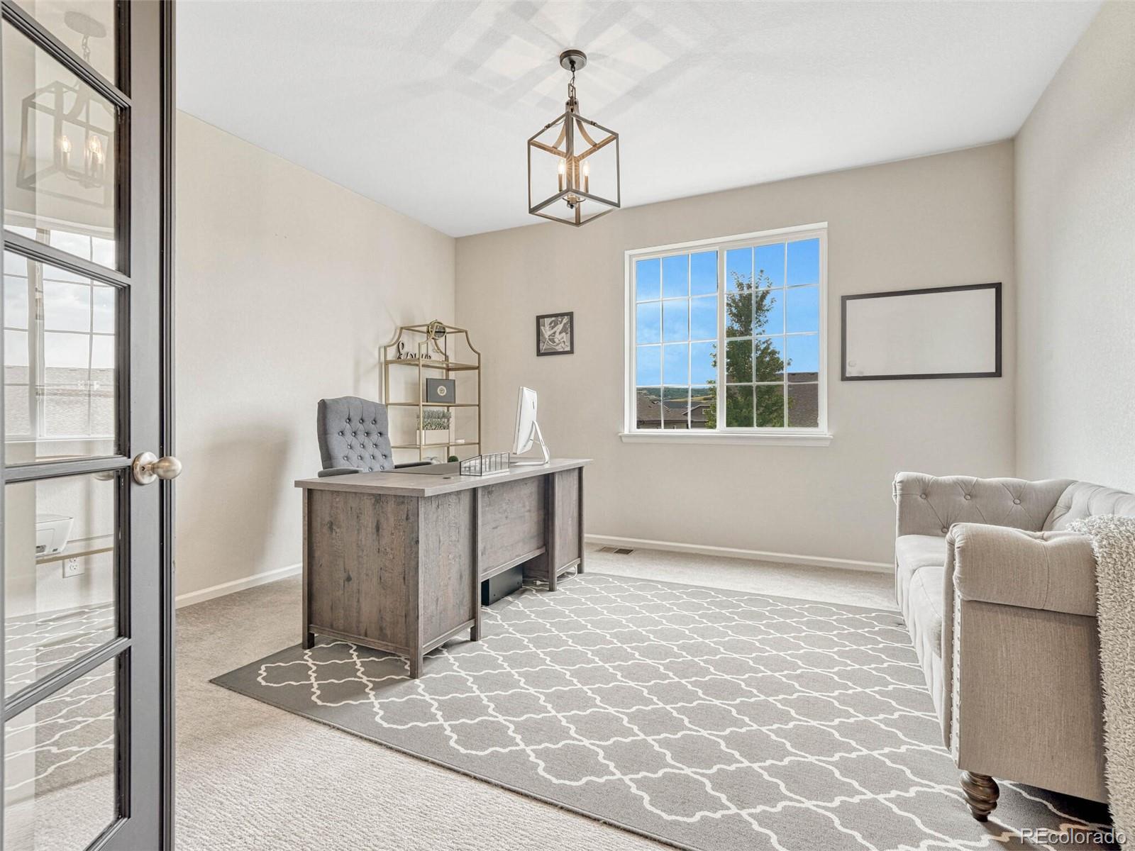 5921 Berry Ridge Wy. Castle Rock, CO 80104 - Photo 14 of 43 a dining room with wooden floor and a chandelier
