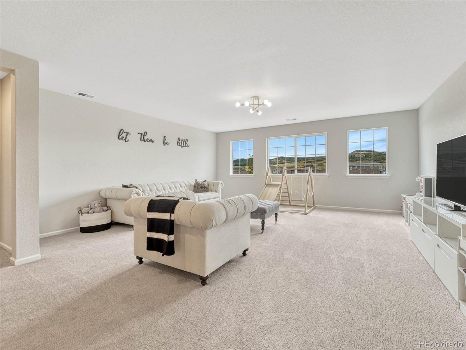 5921 Berry Ridge Wy. Castle Rock, CO 80104 - Photo 16 of 43 a spacious bedroom with a bed and a flat screen television