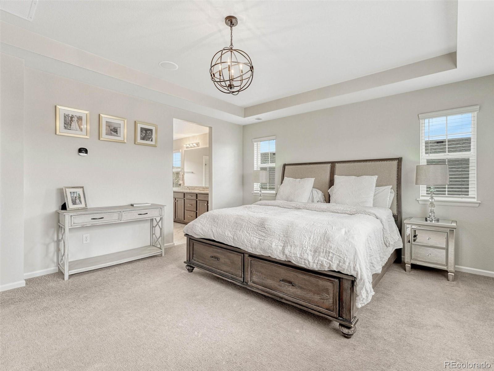 5921 Berry Ridge Wy. Castle Rock, CO 80104 - Photo 21 of 43 a spacious bedroom with a bed and a chandelier