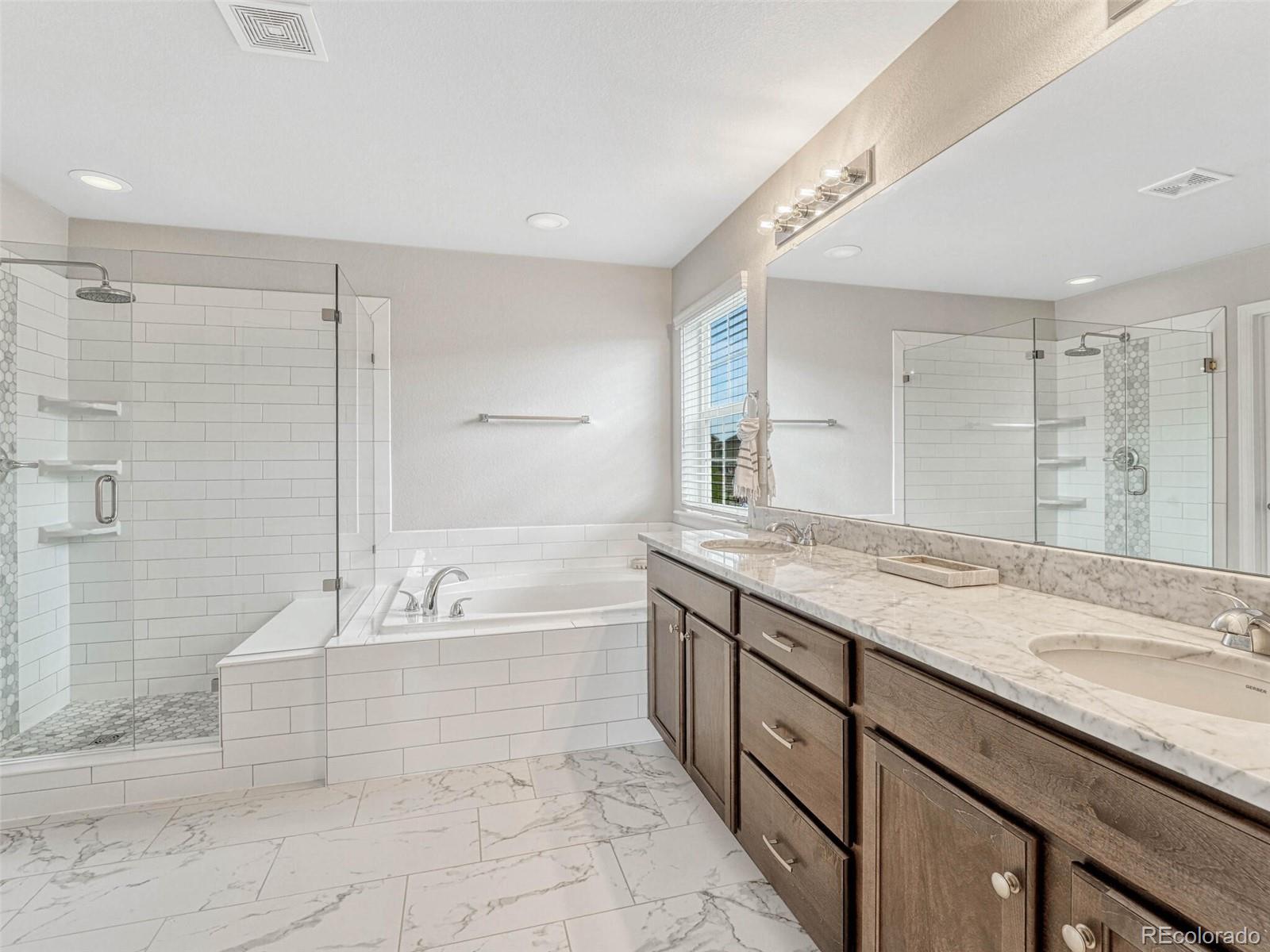 5921 Berry Ridge Wy. Castle Rock, CO 80104 - Photo 24 of 43 a spacious bathroom with a granite countertop tub sink and mirror