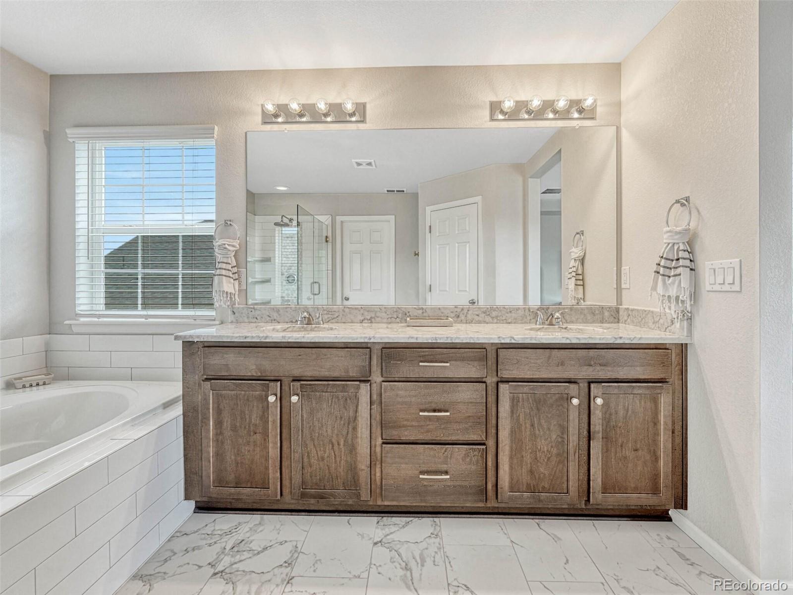 5921 Berry Ridge Wy. Castle Rock, CO 80104 - Photo 25 of 43 a bathroom with a granite countertop bathtub sink and mirror
