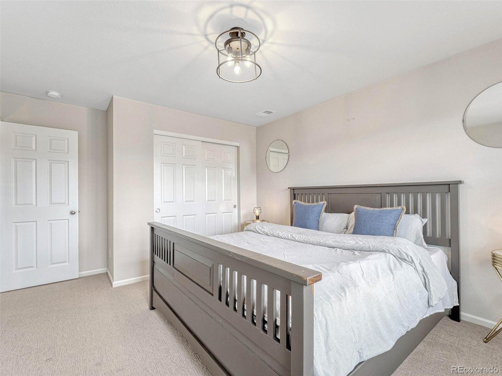 5921 Berry Ridge Wy. Castle Rock, CO 80104 - Photo 29 of 43 a bedroom with a bed and a chandelier