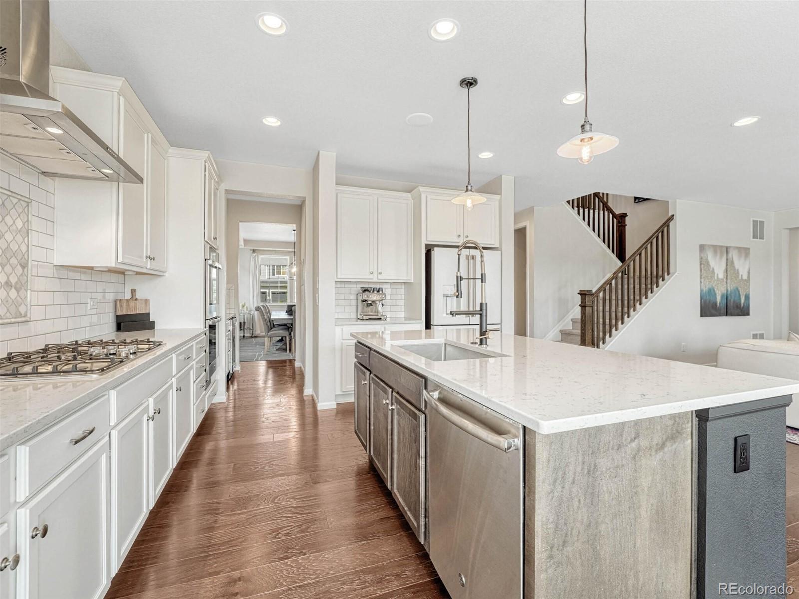 5921 Berry Ridge Wy. Castle Rock, CO 80104 - Photo 6 of 43 a large kitchen with stainless steel appliances kitchen island a large island in the center