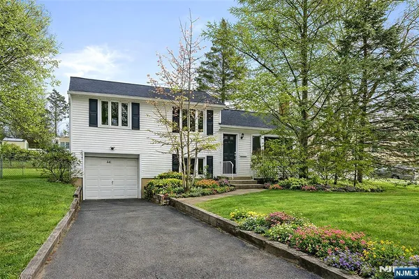 a front view of a house with a yard and trees