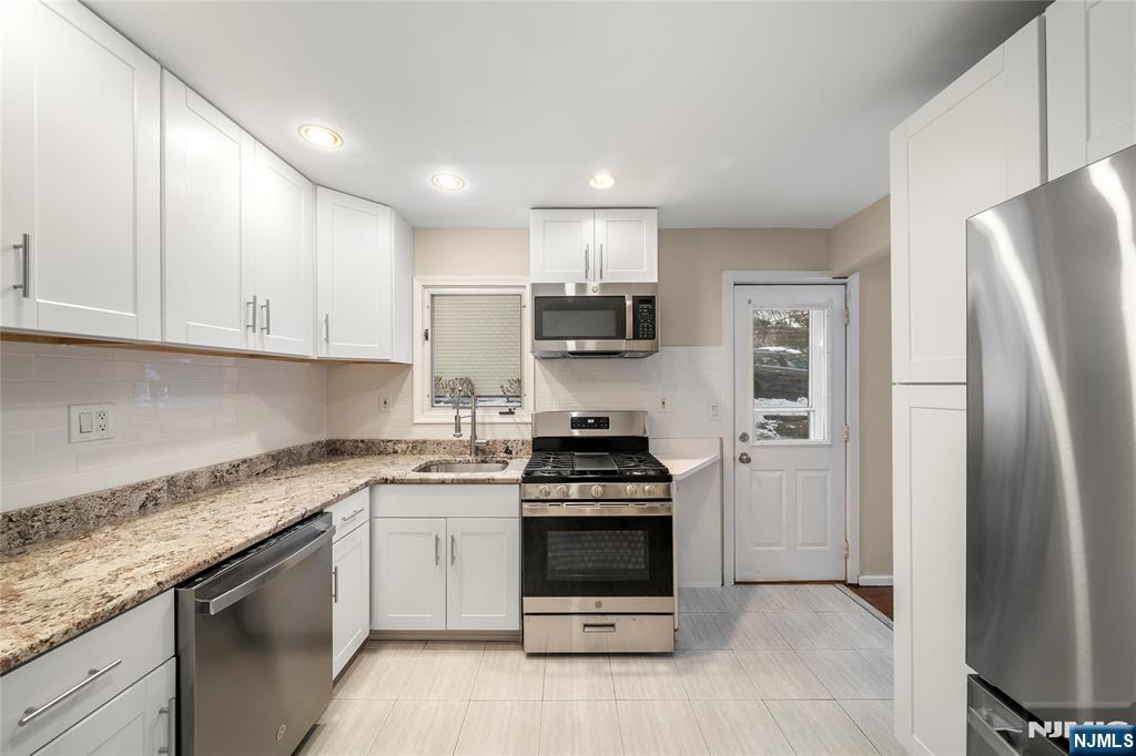 44 Knickerbocker Road Cresskill, NJ 07626 - Photo 11 of 26 a kitchen with stainless steel appliances granite countertop a stove a refrigerator and a sink