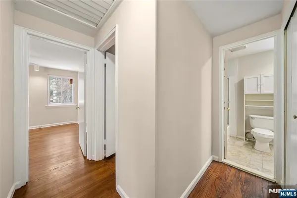 a view of a hallway with wooden floor and a bedroom