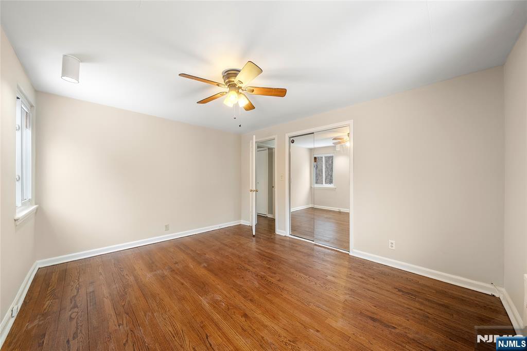 44 Knickerbocker Road Cresskill, NJ 07626 - Photo 14 of 26 an empty room with wooden floor chandelier fan and windows