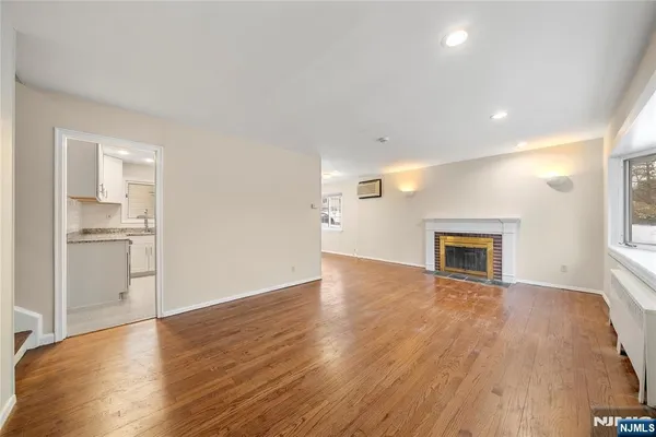 a view of empty room with wooden floor and fireplace