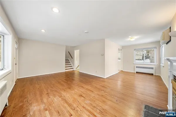 a view of empty room with wooden floor and window