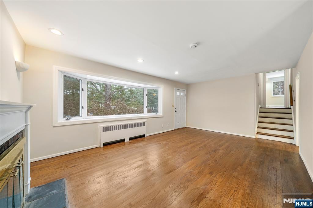 44 Knickerbocker Road Cresskill, NJ 07626 - Photo 6 of 26 a view of an empty room with a window and wooden floor