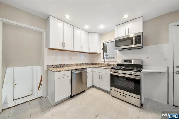 a kitchen with stainless steel appliances granite countertop a stove and a sink