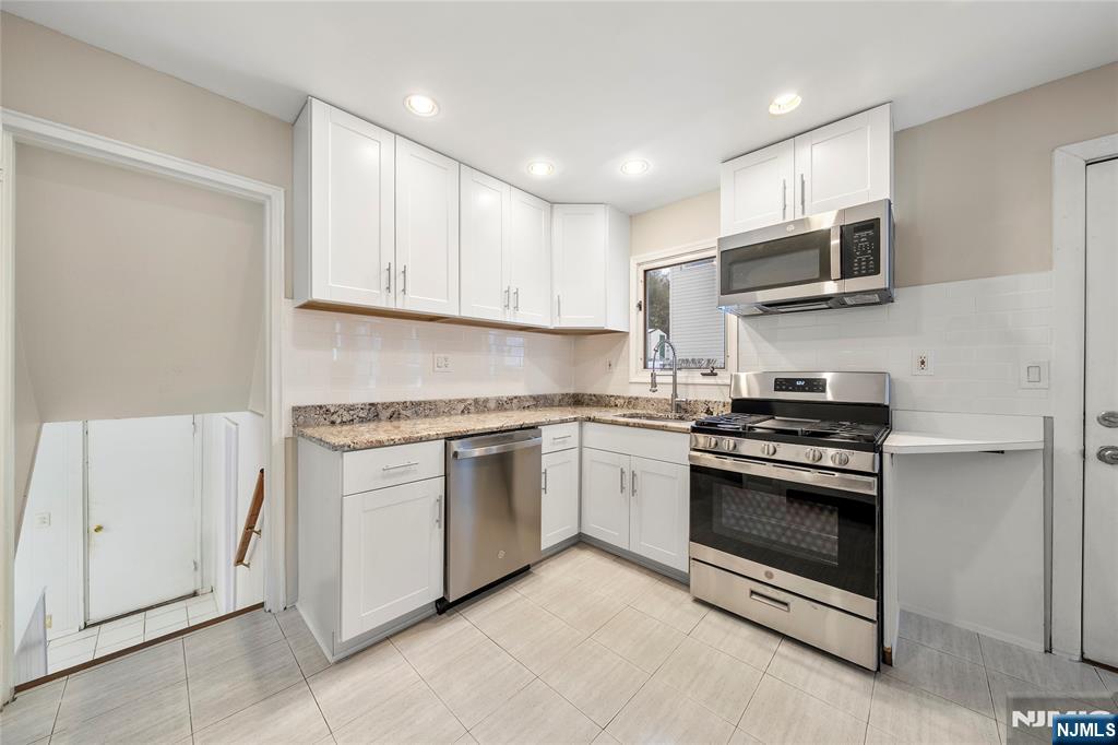 44 Knickerbocker Road Cresskill, NJ 07626 - Photo 9 of 26 a kitchen with stainless steel appliances granite countertop a stove and a sink