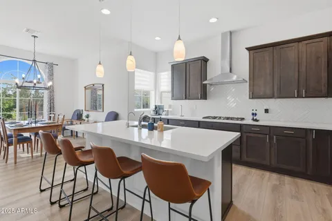 a kitchen with a dining table chairs refrigerator and microwave