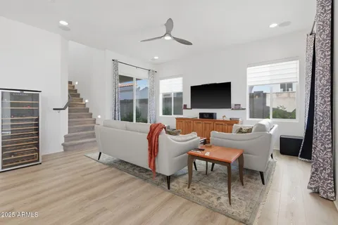a living room with furniture kitchen view and a large window