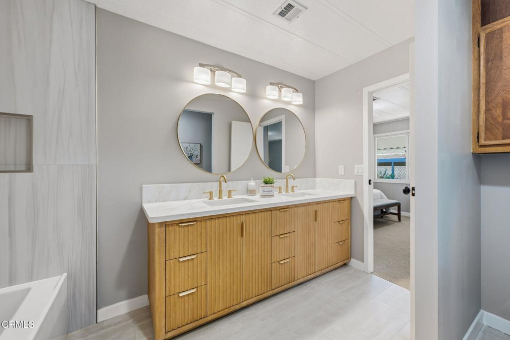 4700 Aurora Drive, Unit 16 Ventura, CA 93003 - Photo 12 of 28 a bathroom with a double vanity sink and a mirror