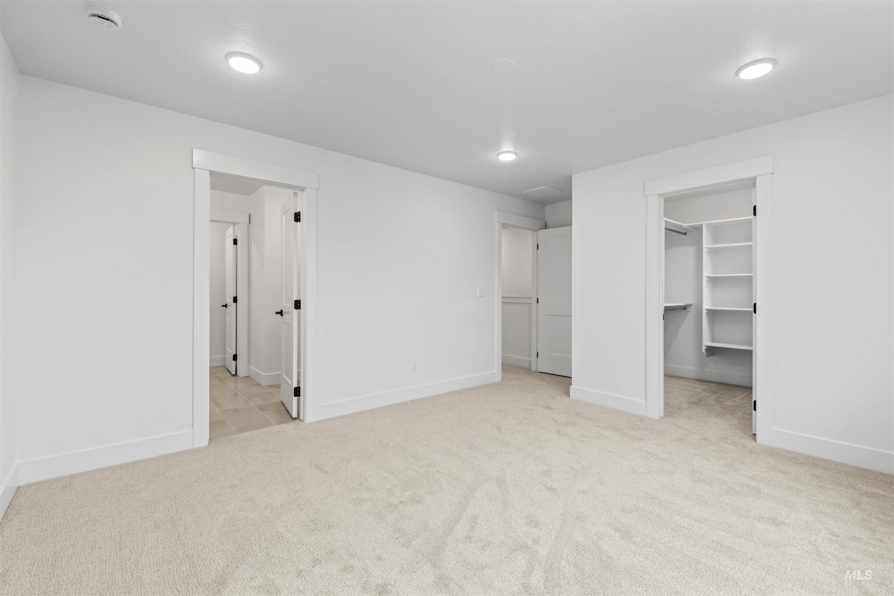 2168 East Deep Purple Lane Meridian, ID 83642 - Photo 7 of 15 Unfurnished bedroom with a walk in closet and light carpet