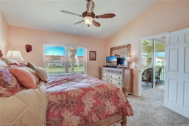 a bed sitting in a bedroom next to a window with a flat screen tv