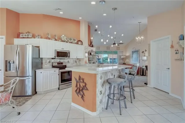 a kitchen with stainless steel appliances kitchen island granite countertop a refrigerator and microwave