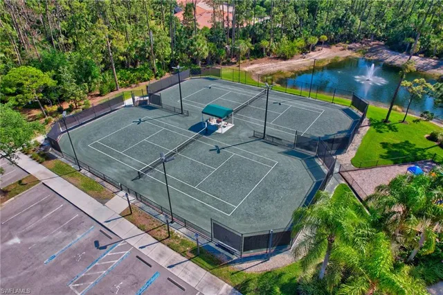 a view of a tennis ground with large trees