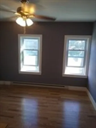 a view of a livingroom with wooden floor and a window