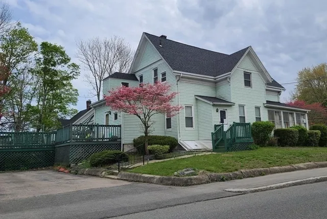 a front view of a house with a garden and plants