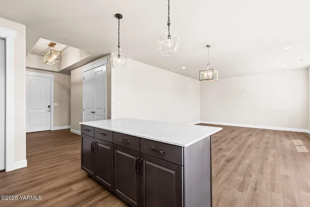 a kitchen with a sink a center island and a wooden floor
