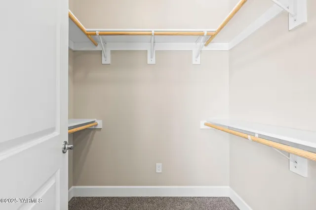 a view of walk in closet with empty racks