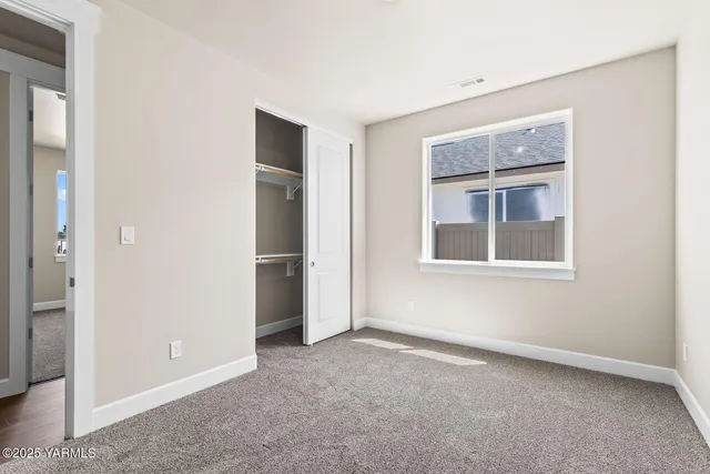 an empty room with windows and closet