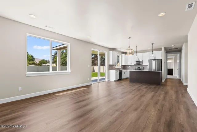a view of a kitchen with furniture and wooden floor