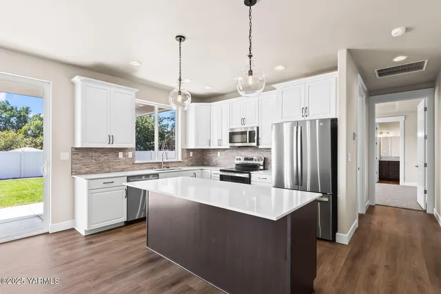a kitchen with kitchen island a sink a stove a refrigerator and blue cabinets