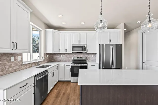 a kitchen with kitchen island a sink stainless steel appliances and window