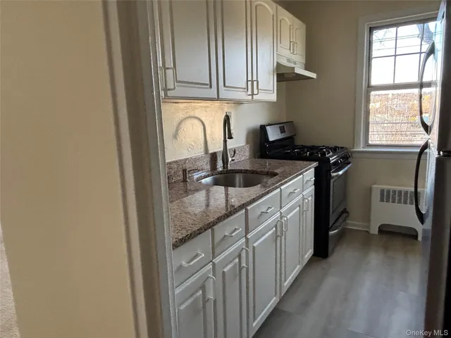 a kitchen with stainless steel appliances granite countertop a sink stove and cabinets
