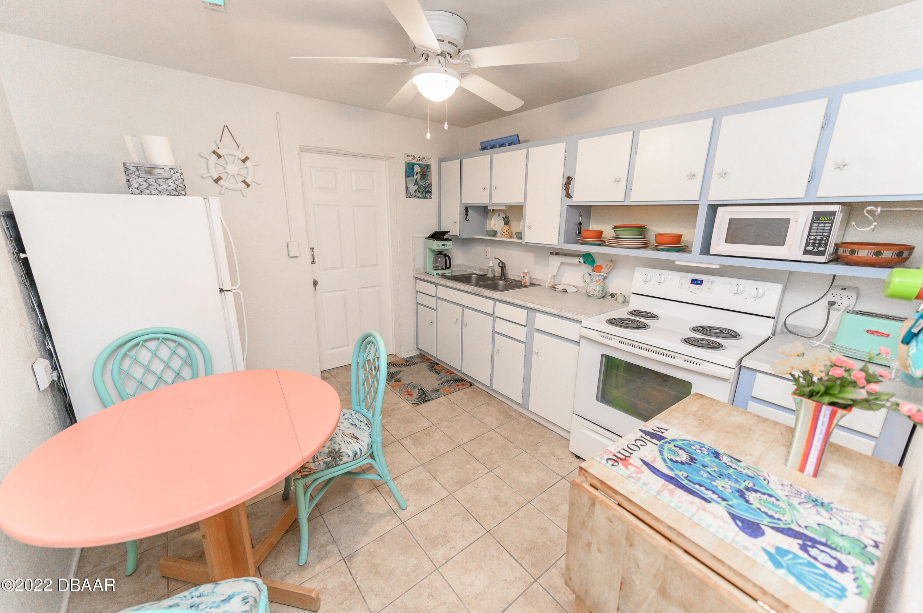 56 Margaret Road Ormond Beach, FL 32176 - Photo 23 of 32 a kitchen with stainless steel appliances a stove a sink cabinets and a dining table