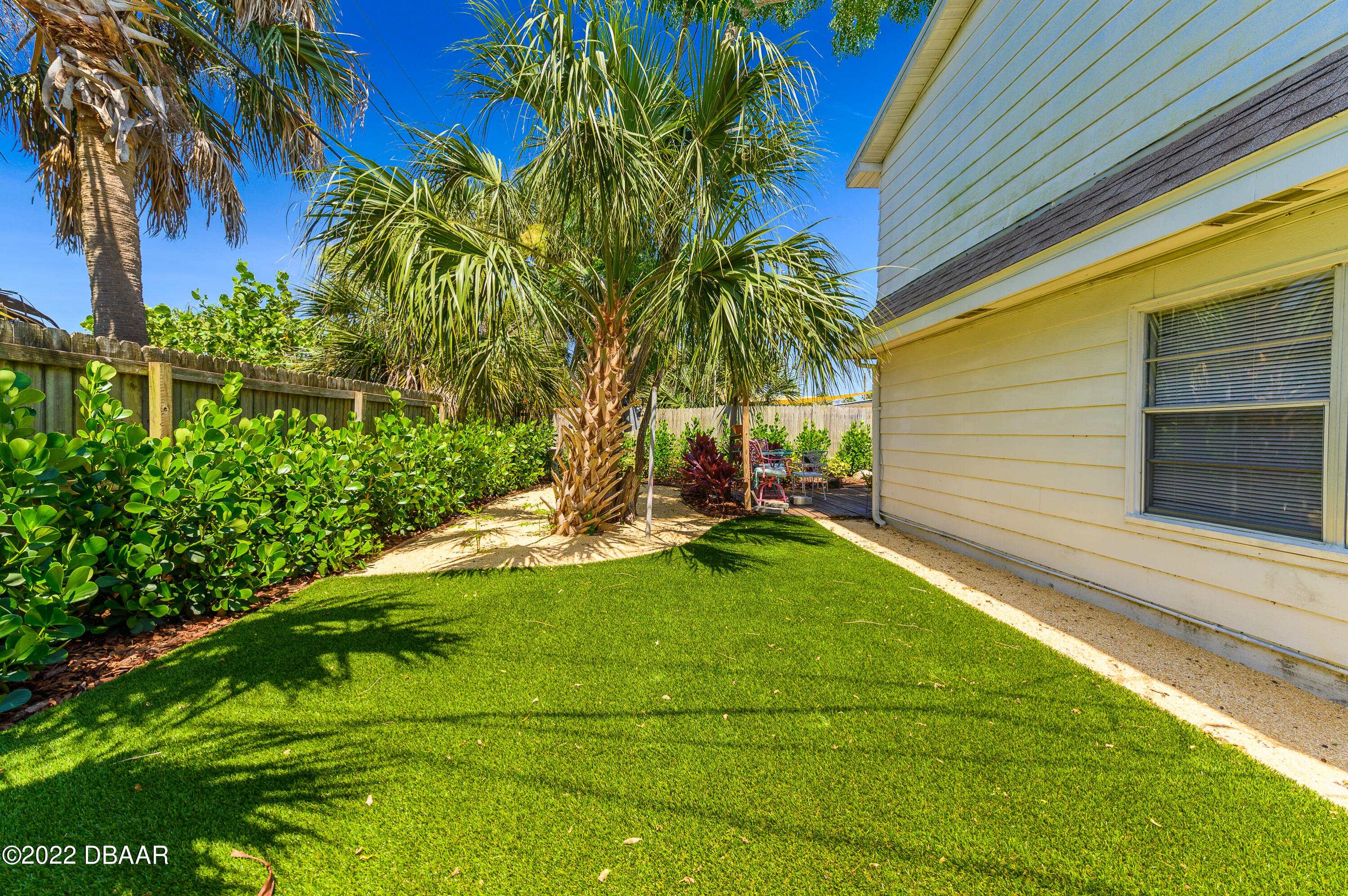 56 Margaret Road Ormond Beach, FL 32176 - Photo 10 of 32 a view of a backyard with plants and a lawn chairs