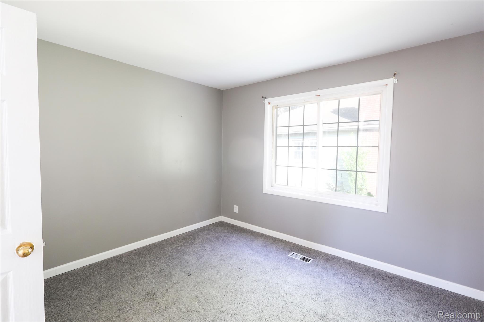 3319 Lakeview Street Monroe, MI 48162 - Photo 17 of 21 Room featuring a window with grid inserts, gray wall paint, and gray carpeting