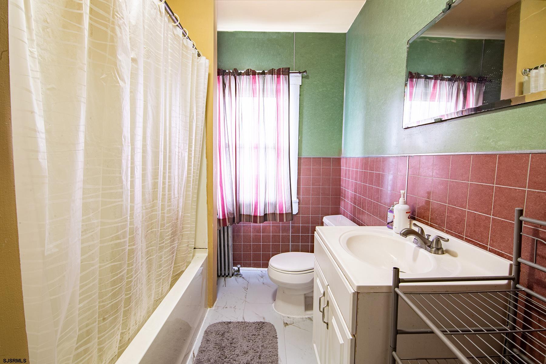 638 Wisteria Road Atlantic City, NJ 08401 - Photo 29 of 33 a bathroom with a sink a toilet and shower curtain