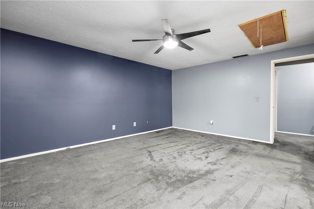 18042 Howe Road Strongsville, OH 44136 - Photo 27 of 35 Empty room featuring carpet flooring, ceiling fan, and a textured ceiling