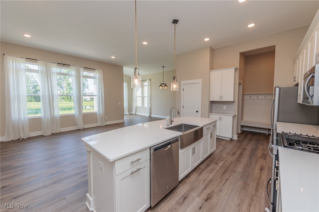 36458 Appian Way North Ridgeville, OH 44039 - Photo 12 of 37 Kitchen featuring appliances with stainless steel finishes, a center island with sink, white cabinetry, and light hardwood / wood-style flooring