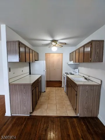 a kitchen with stainless steel appliances granite countertop a stove a sink dishwasher and a microwave oven with wooden cabinets