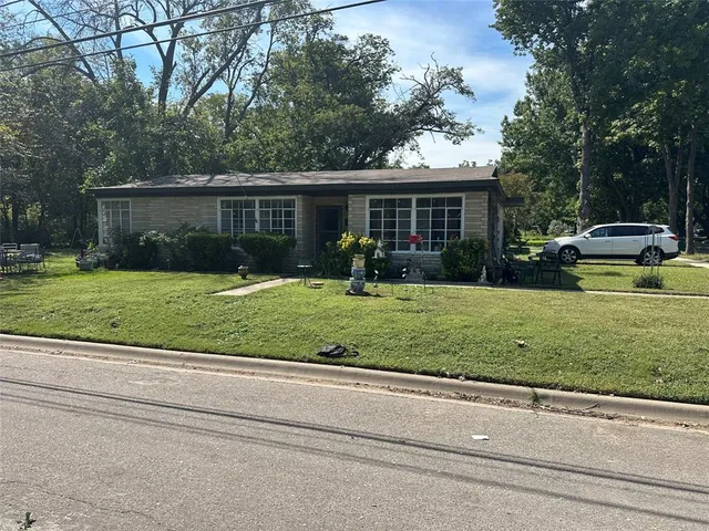 a front view of a house with a yard and trees