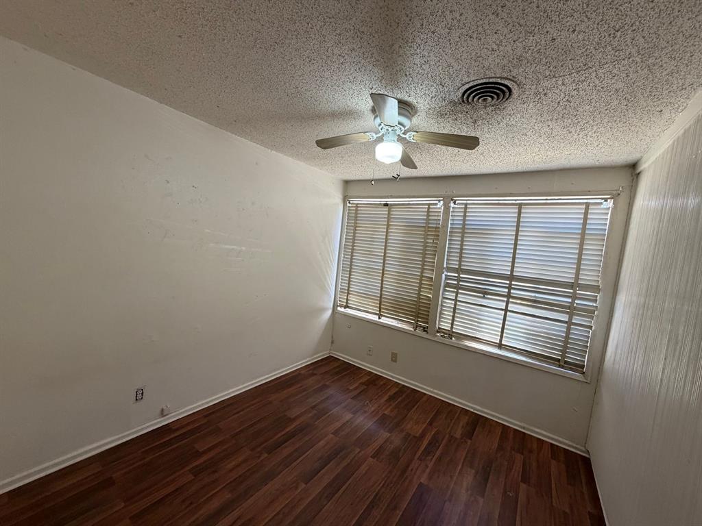 1225 Coit Street Denton, TX 76201 - Photo 7 of 13 a view of an empty room with a window and wooden floor