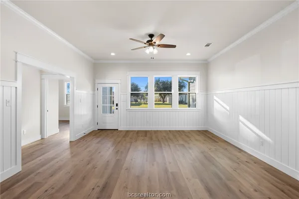 a view of an empty room with window and wooden floor