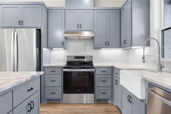 a kitchen with cabinets stainless steel appliances and sink