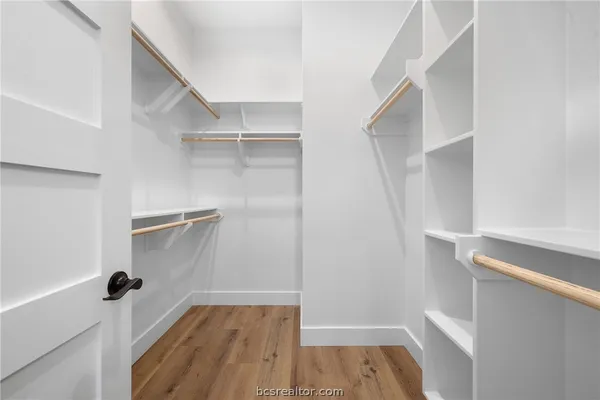 a view of walk in closet with empty racks