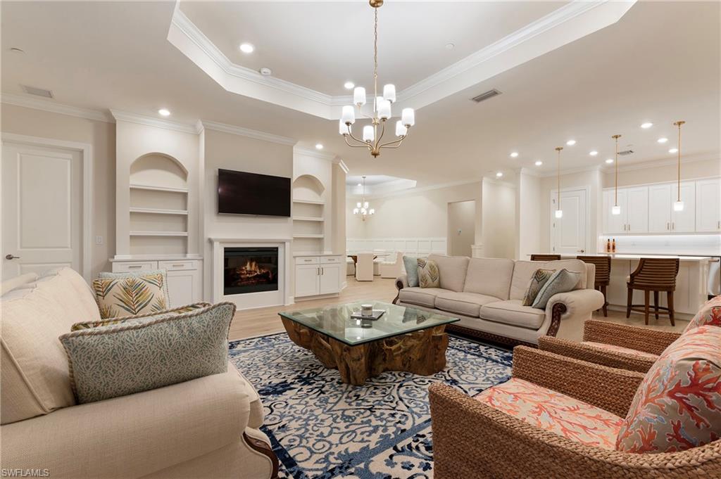 15328 Lucerna Street, Unit 202 Naples, FL 34114 - Photo 5 of 32 a living room with furniture a fireplace and a flat screen tv